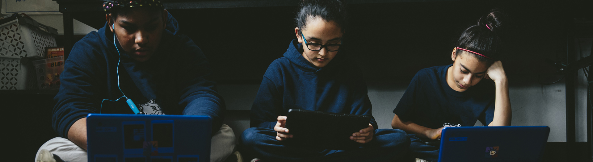 Three students on devices