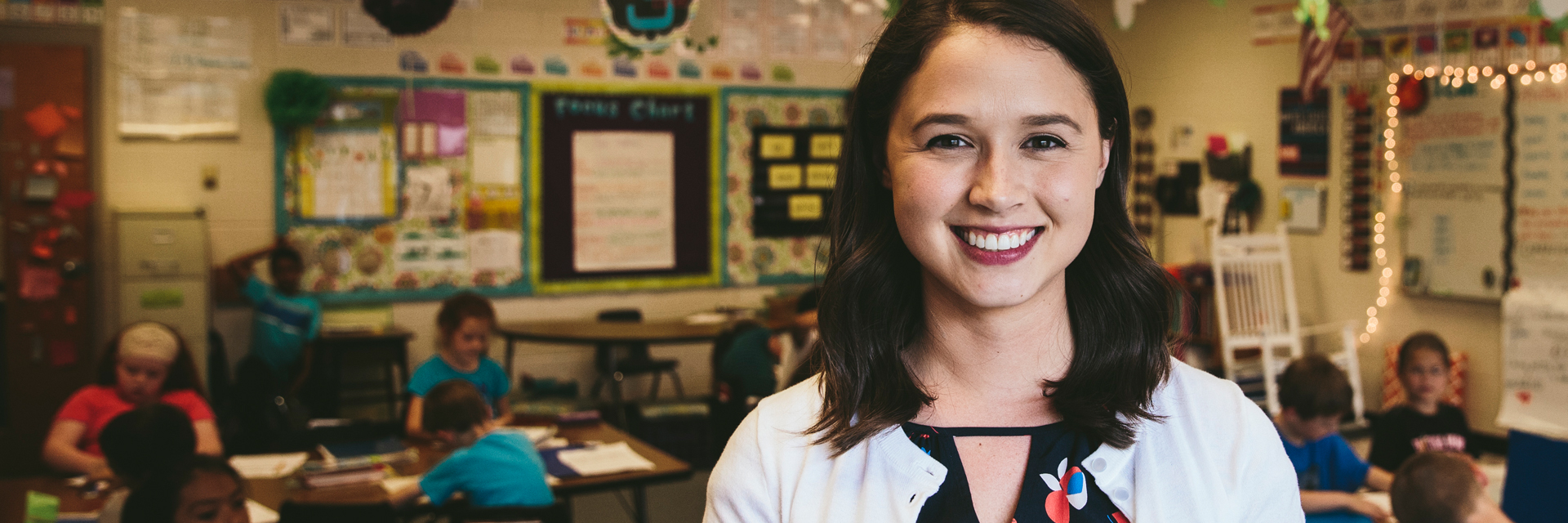 Teacher in classroom smiling.