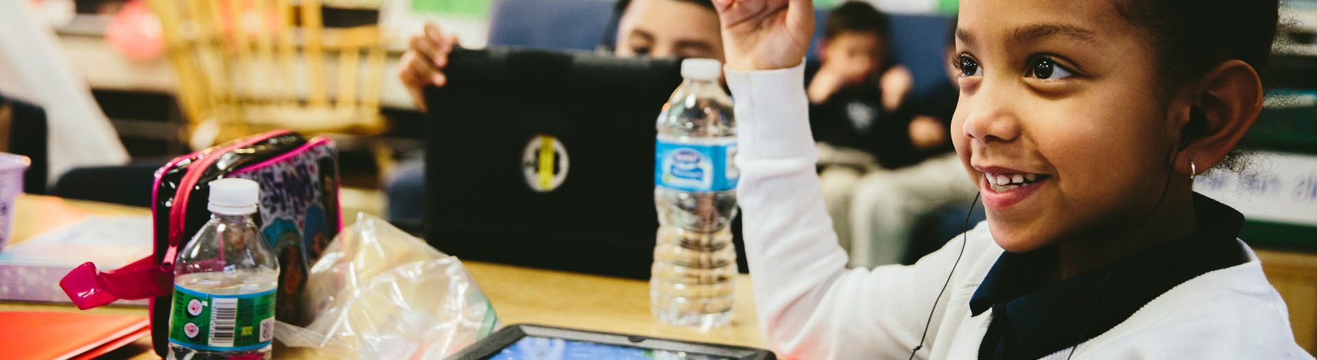 Student raising hand in classroom