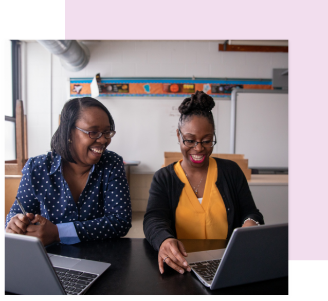 Two women laughing viewing laptop.